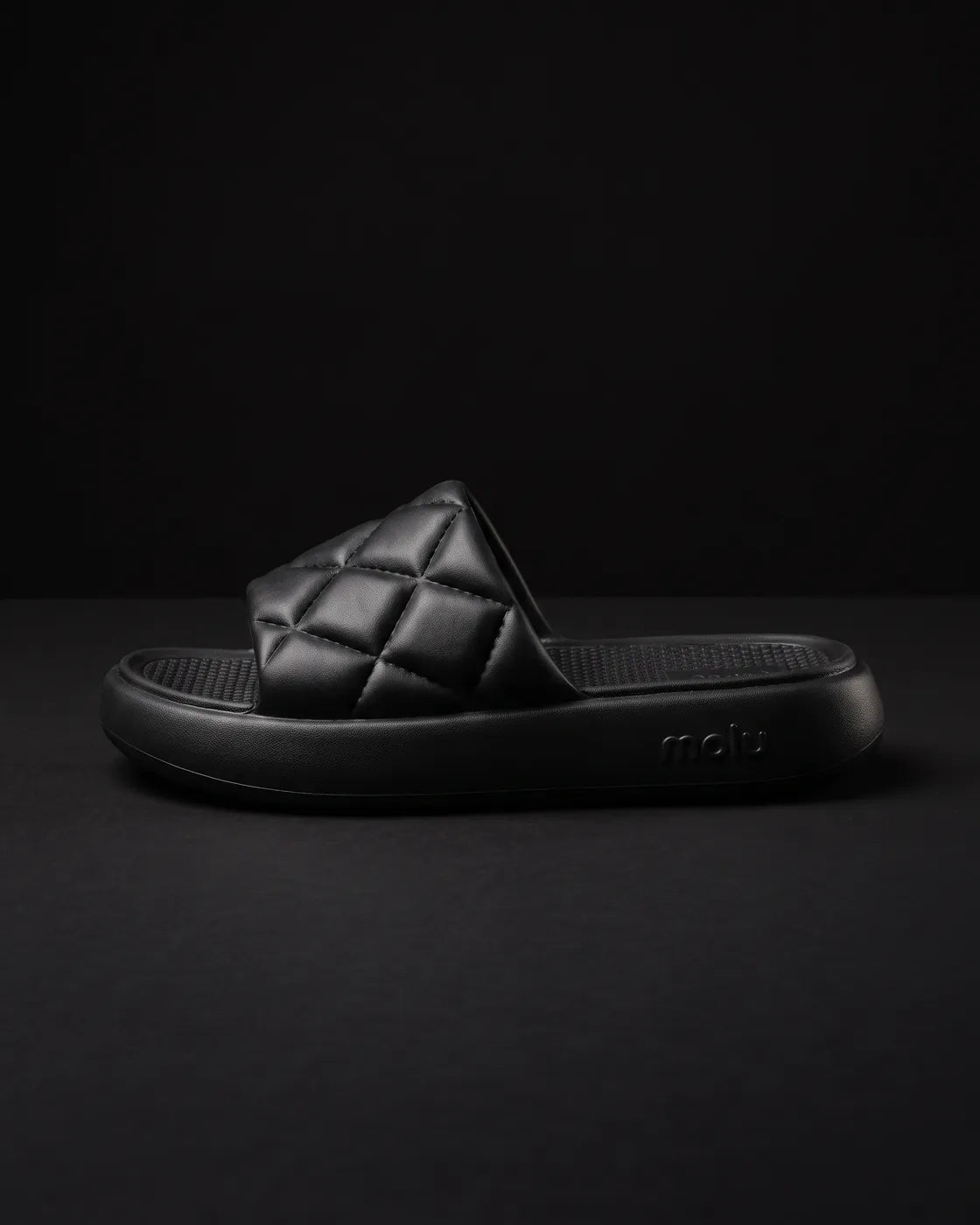Chinelo molu Luxo preto, de lado, com a tira matelassê