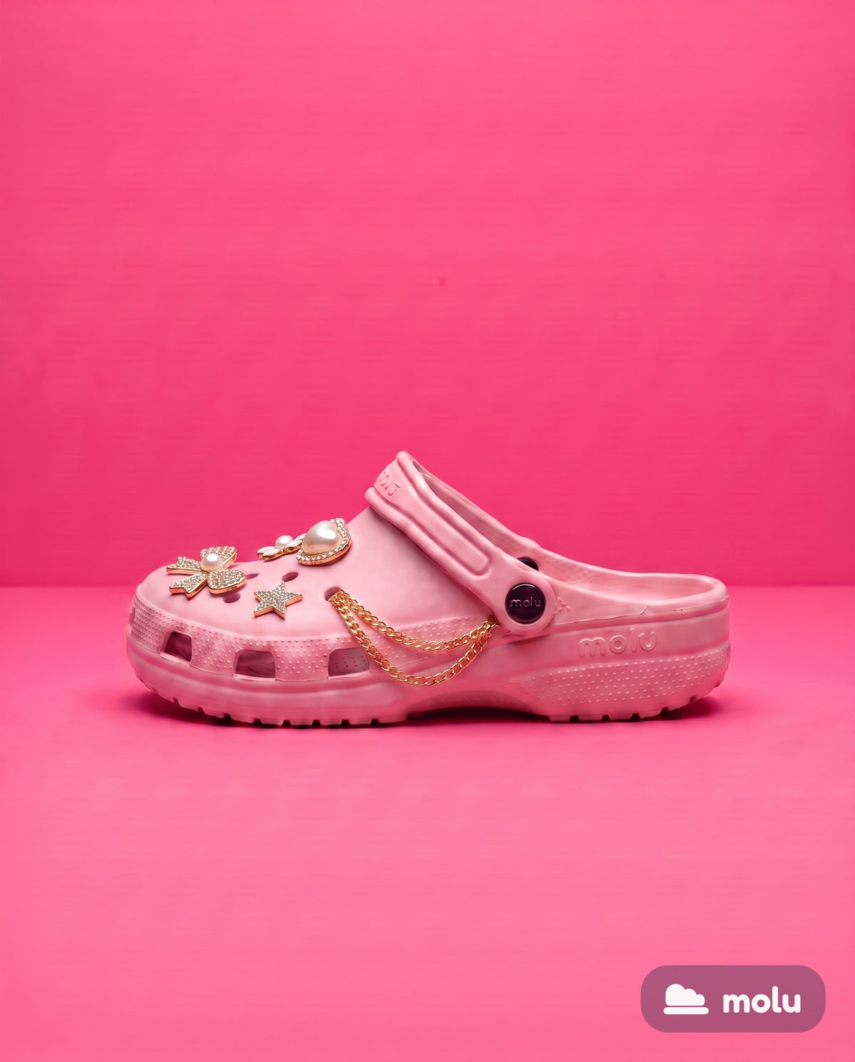 Babuche molu Clássico rosa com pingentes dourados, visto de lado